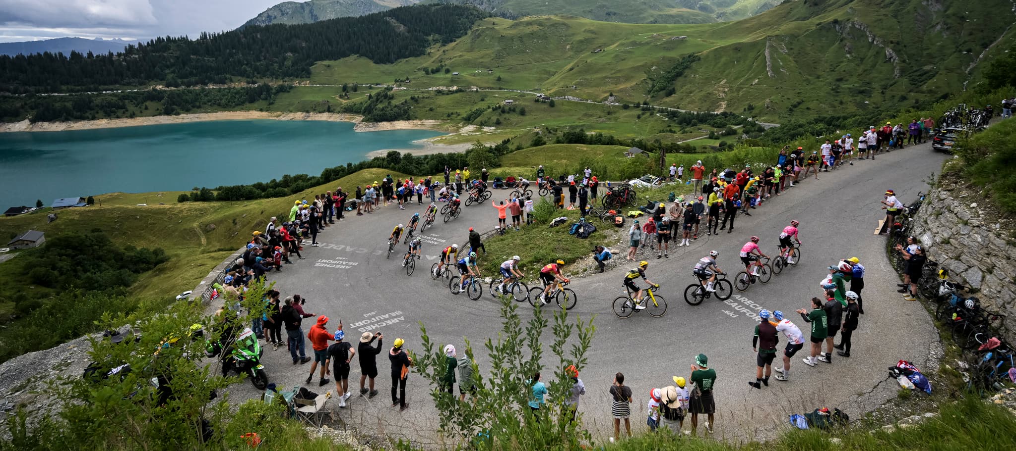 Peloton climbs a winding road, Tour de France 2025